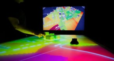 The user interface of our CDP, it showcases a large horizontal touchscreen with building models on top